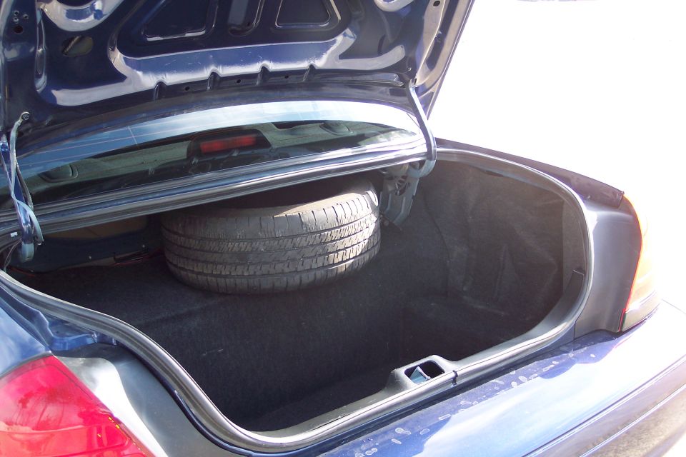 Trunk of a 2001 Ford Crown Victoria with spare tire visible
