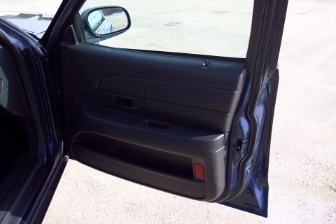 2001 Ford Crown Victoria - Interior door panel of a 2001 Ford Crown Victoria, showing the dark blue trim and power window controls.