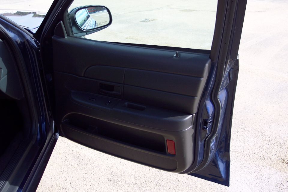 Dark blue interior door panel of a 2001 Ford Crown Victoria with open door