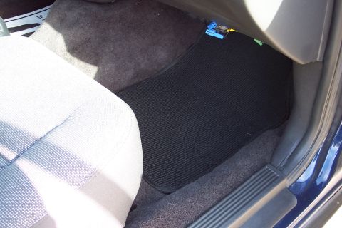 2001 Ford Crown Victoria - Interior view of a car's floor mats and seat.