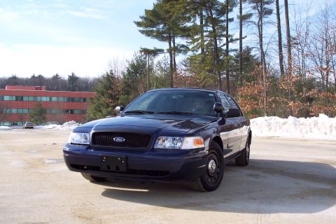 2001 Ford Crown Victoria - A dark blue 2001 Ford Crown Victoria sedan is parked outside on a sunny day with snow in the background.