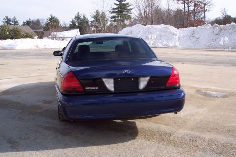 2001 Ford Crown Victoria - Rear view of a blue 2001 Ford Crown Victoria parked outdoors in a lot with snow visible.
