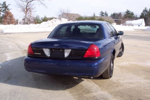 2001 Ford Crown Victoria - Rear view of a blue 2001 Ford Crown Victoria sedan in a snowy parking lot.