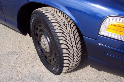 2001 Ford Crown Victoria - Close-up of the front wheel and fender of a blue 2001 Ford Crown Victoria.