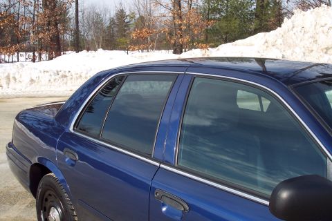 2001 Ford Crown Victoria - A blue sedan is parked outside with snow piled up in the background.