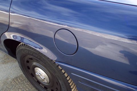 2001 Ford Crown Victoria - The reflective blue paint on the side of the vehicle shows a cloudy sky.