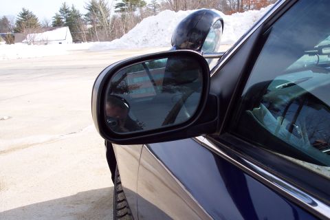 2001 Ford Crown Victoria - A dark blue sedan is parked on a snowy lot, with the driver's side mirror reflecting the photographer.