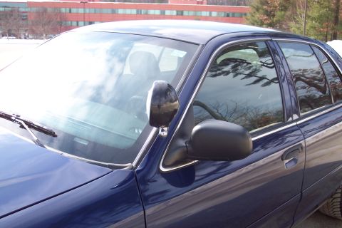 2001 Ford Crown Victoria - Side view of a blue 2001 Ford Crown Victoria sedan with black mirrors.