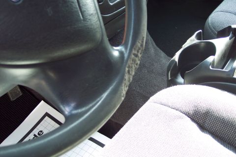 2001 Ford Crown Victoria - Interior view of a vehicle's steering wheel and passenger seat, with a document fragment visible.