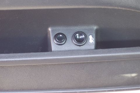 2001 Ford Crown Victoria - Close-up of a car's interior door panel, showing two buttons and a trunk release symbol.
