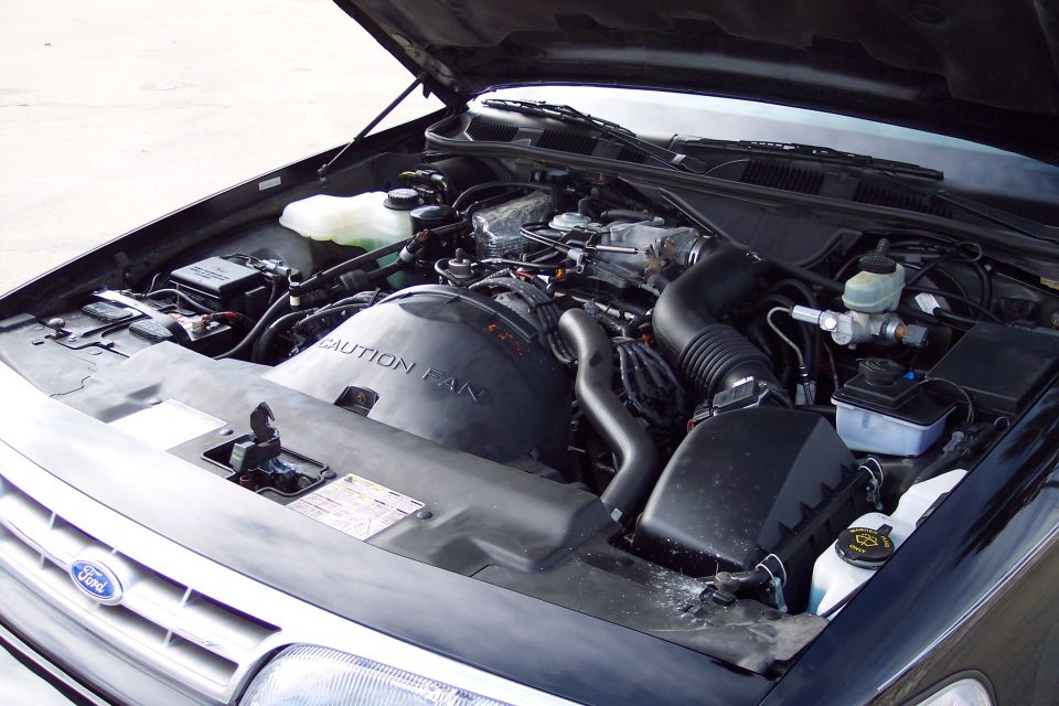 2001 Ford Crown Victoria engine bay with hood open, showing V8 engine, air intake, and battery