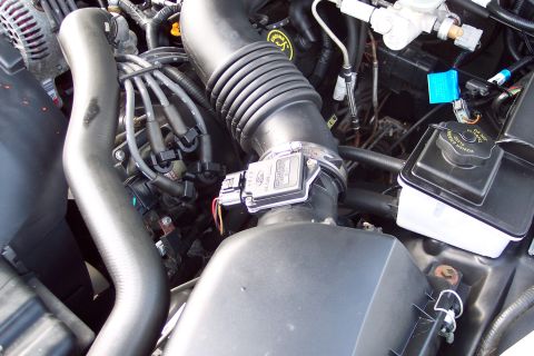 2001 Ford Crown Victoria - Close-up of the engine bay in a 2001 Ford Crown Victoria, focusing on the air intake system.