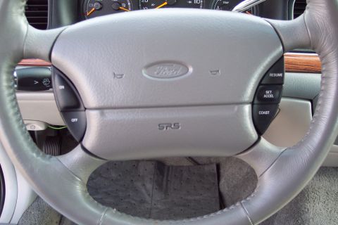 2001 Ford Crown Victoria - Interior view of a Ford Crown Victoria's steering wheel and dashboard, showing the Ford emblem and SRS airbag indicator.