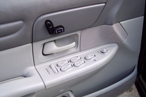 2001 Ford Crown Victoria - Close-up of the driver's side door panel, power window and seat controls.
