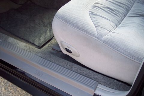 2001 Ford Crown Victoria - The interior of a 2001 Ford Crown Victoria shows the driver's seat with light grey fabric and power seat controls visible.