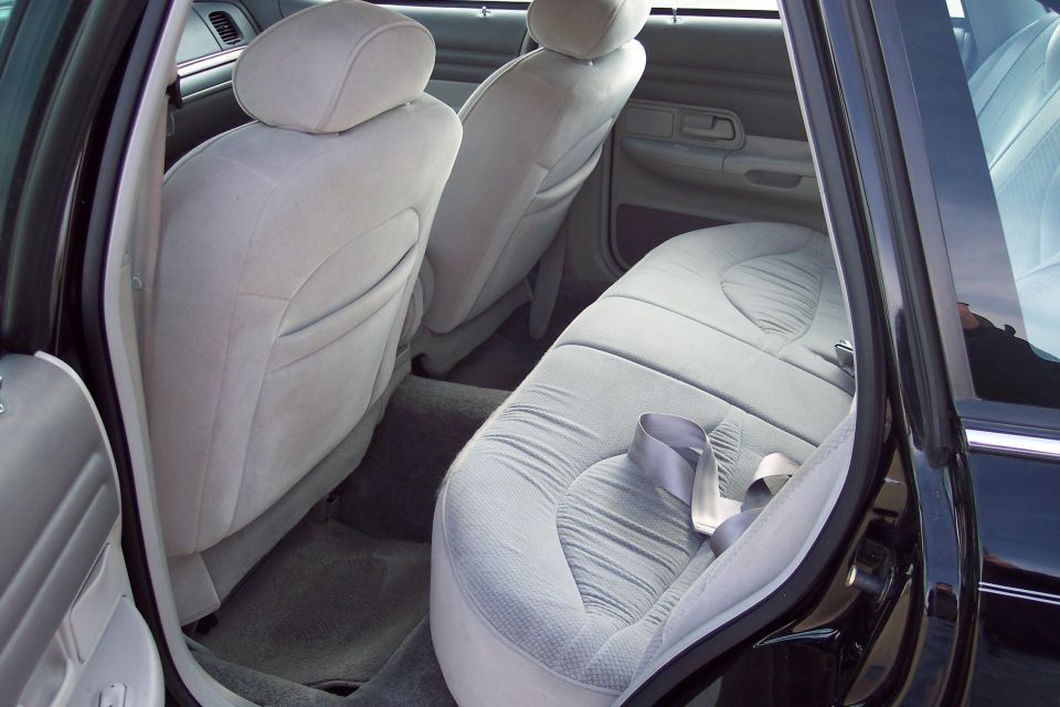 Gray cloth rear seats and floor of a 2001 Ford Crown Victoria, viewed from the driver's side rear door opening