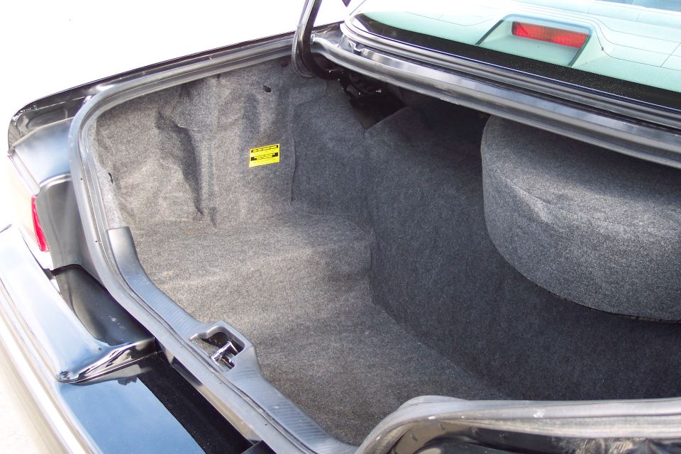 Trunk interior with spare tire and yellow warning sticker