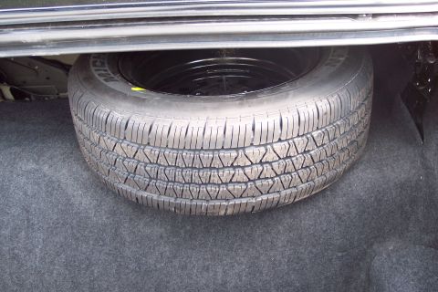 2001 Ford Crown Victoria - Spare tire with Michelin branding visible in the trunk of a vehicle.