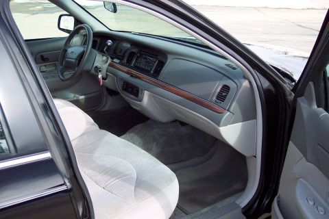 2001 Ford Crown Victoria - The interior of a 2001 Ford Crown Victoria is shown, cloth seats and wood trim accents on the dashboard.