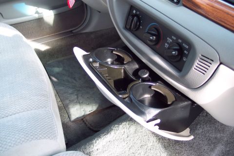 2001 Ford Crown Victoria - Close-up of the center console in a Ford Crown Victoria, showing the cup holders and climate controls.