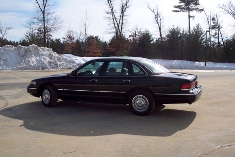 2001 Ford Crown Victoria - Side view of a black 2001 Ford Crown Victoria parked on a paved surface.