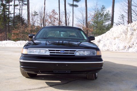 2001 Ford Crown Victoria - Frontal view of a black 2001 Ford Crown Victoria, showing its grille and headlights.