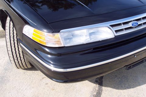 2001 Ford Crown Victoria - Front corner view of a black 2001 Ford Crown Victoria, highlighting its chrome trim and headlights.