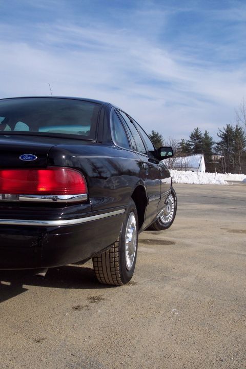 2001 Ford Crown Victoria - Rear view of a black 2001 Ford Crown Victoria parked outdoors with snow in the background.