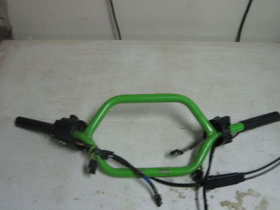 Green snowmobile handlebars with black grips and wiring