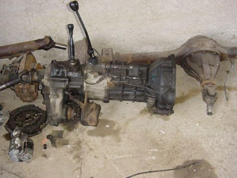 1992 Ford Bronco - Transfer case, driveshaft, and rear differential assembly with clutch and starter motor.