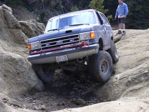 1991 Ford Bronco - A man watches as a Ford Bronco navigates a difficult rocky terrain.