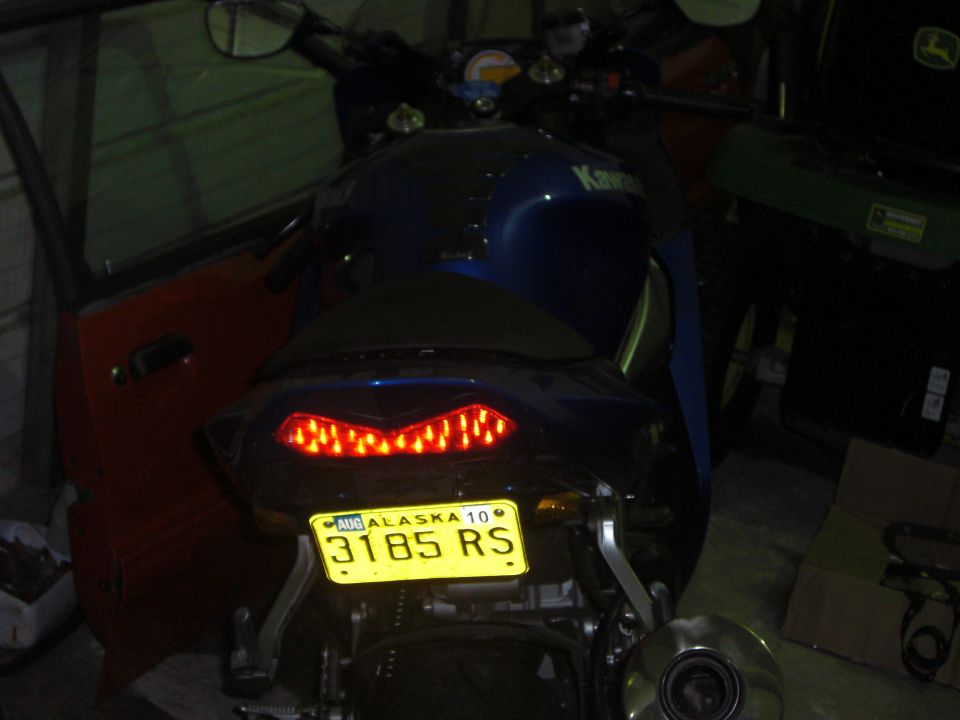 Motorcycle rear with yellow Alaska license plate 3185 RS and red LED taillight