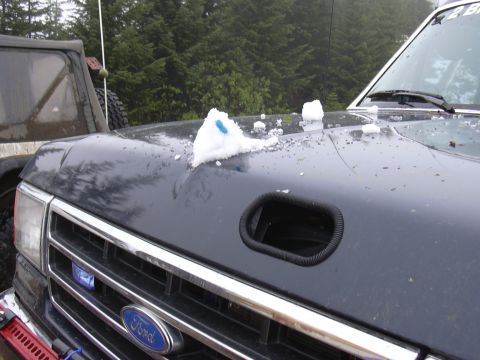1991 Ford Bronco - A 1991 Ford Bronco's hood is covered in snow, with a snorkel intake visible.