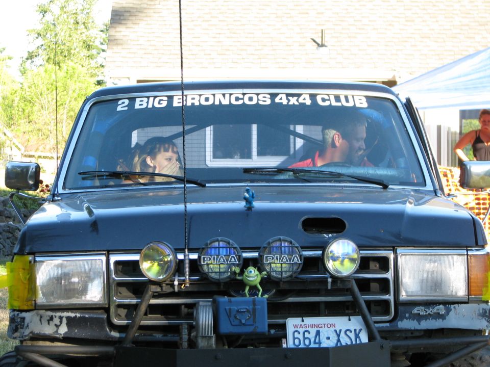 Black Ford Bronco with off-road lights and a "2 BIG BRONCOS 4X4 CLUB" sticker on the windshield