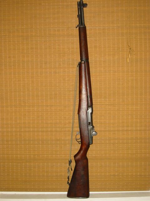 1996 Ford Bronco - A vintage M1 Garand rifle is shown with its sling attached, displayed against a woven blind.