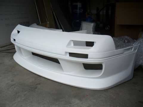 1987 Mazda RX-7 - Front bumper for a 1987 Mazda RX-7, likely an aftermarket part, shown unpainted.