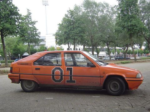 1991 Ford Crown Victoria - This orange hatchback has the number 01 painted on its side.