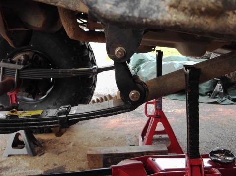 1990 Ford Bronco - Vehicle suspension components are visible while the vehicle is supported by jack stands for repair.