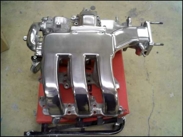chrome intake manifold on a red stand