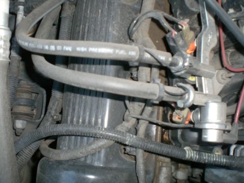 2000 Mercury Grand Marquis - Close-up view of engine fuel lines and associated components, showing potential signs of wear and leaks.