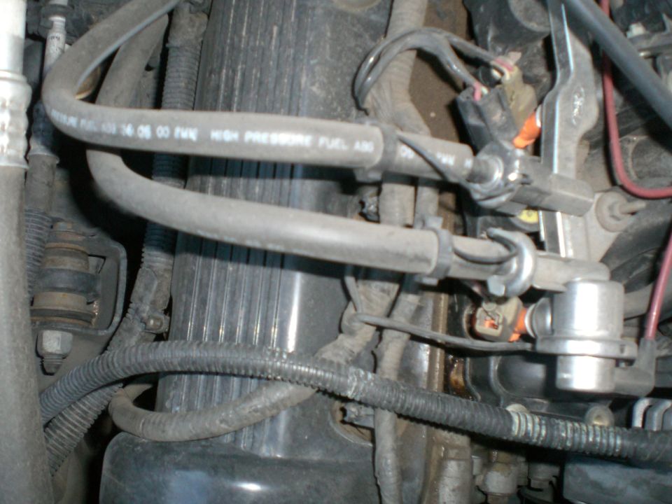 Engine fuel lines and connectors, some with visible wear and oil residue