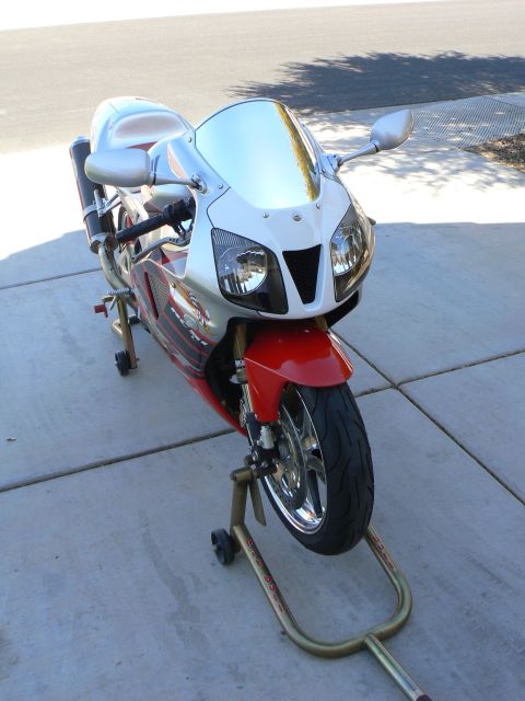1978 Ford Bronco - Sport motorcycle with red front fender and white fairing is on display stands.
