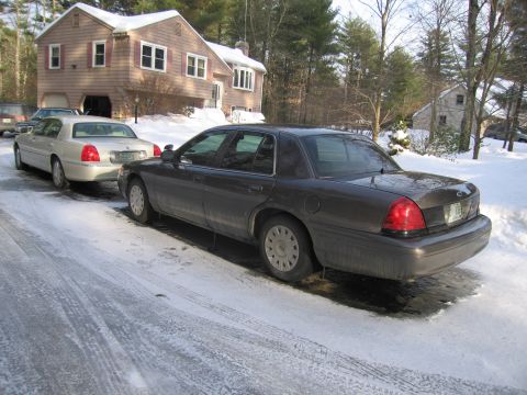 1991 Ford Crown Victoria LTD - Two sedans parked on a snow-covered driveway in front of a house.