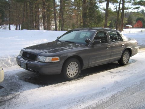1991 Ford Crown Victoria LTD - A dark gray sedan is parked on a snowy driveway, showing its 3/4 front profile.