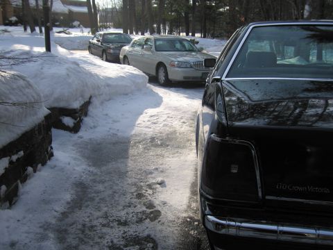 1991 Ford LTD Crown Victoria - A black 1991 Ford Crown Victoria LTD is parked in a snowy driveway next to other vehicles.