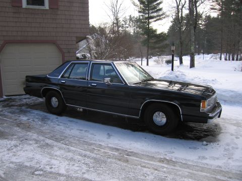 1991 Ford LTD Crown Victoria - A black sedan sits in a snowy driveway during winter.