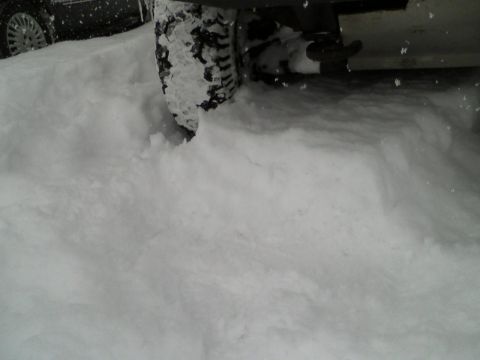 2000 Chevrolet Tahoe - A vehicle tire is stuck in deep snow, with another vehicle nearby.