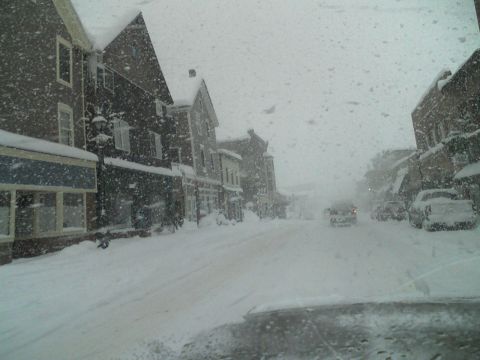 2000 Chevrolet Tahoe - A snowstorm blankets a town street, making driving conditions difficult.