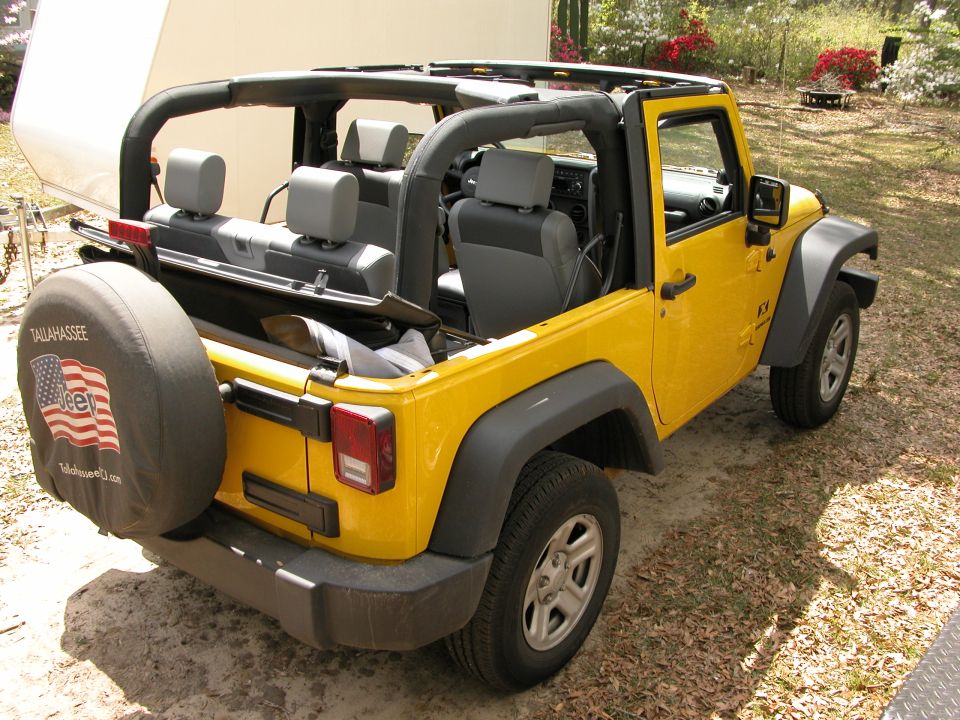 Yellow Jeep Wrangler with spare tire cover showing American flag and 'Tallahassee Jeep'