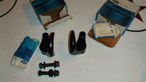 1979 Ford Bronco - Two black Ford Bronco parts, possibly rocker arms, are shown with bolts and original Ford Service Parts packaging.